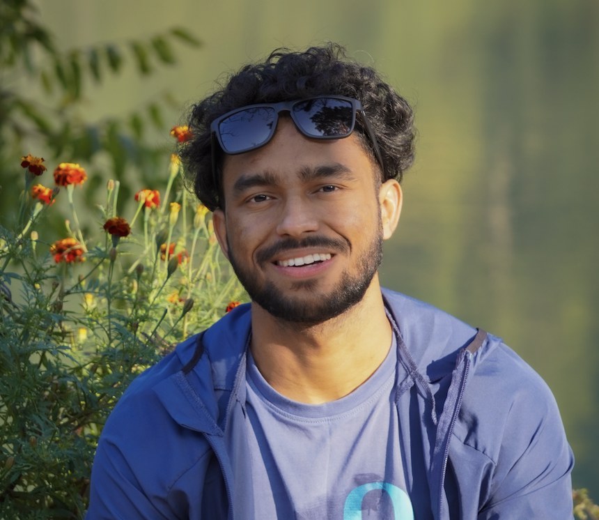 Manish Tamta, smiling, outdoors in the mountains
